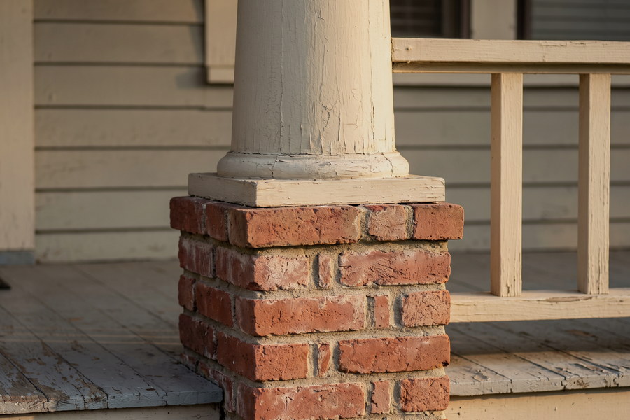 Detail of a bungalow porch with tapered columns on brick piers.