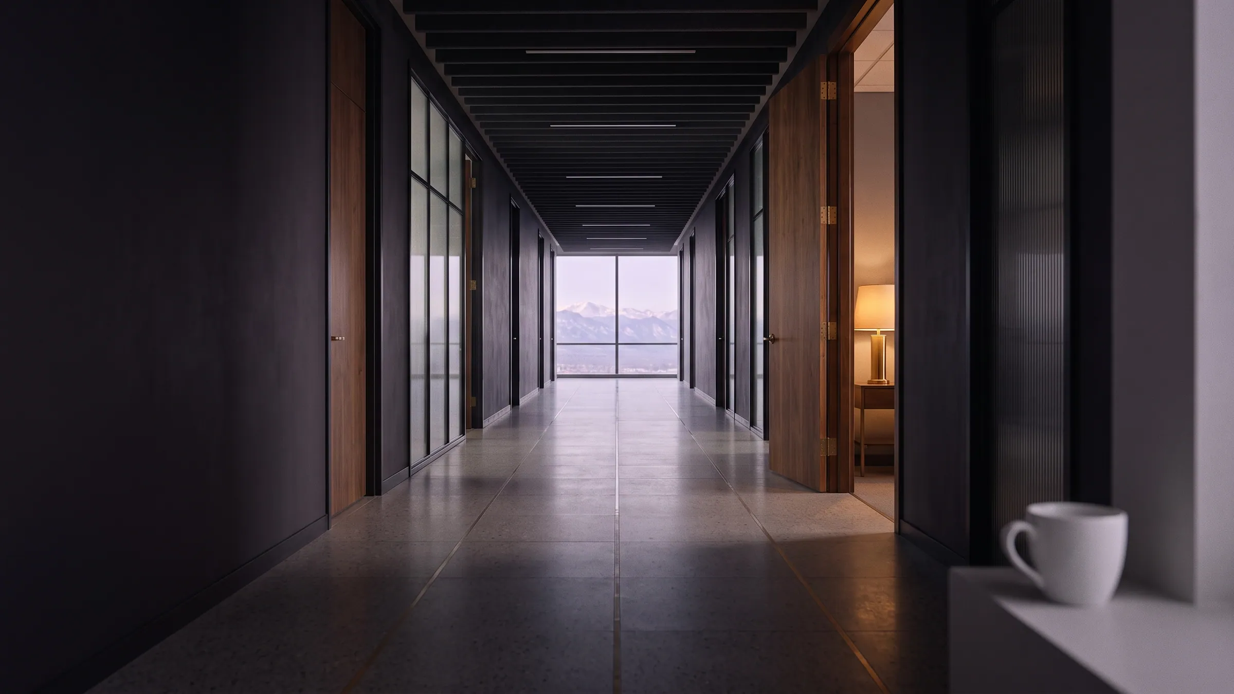 The firm’s long corridor at 7:42 in the morning, empty, with the mountains at the far end.