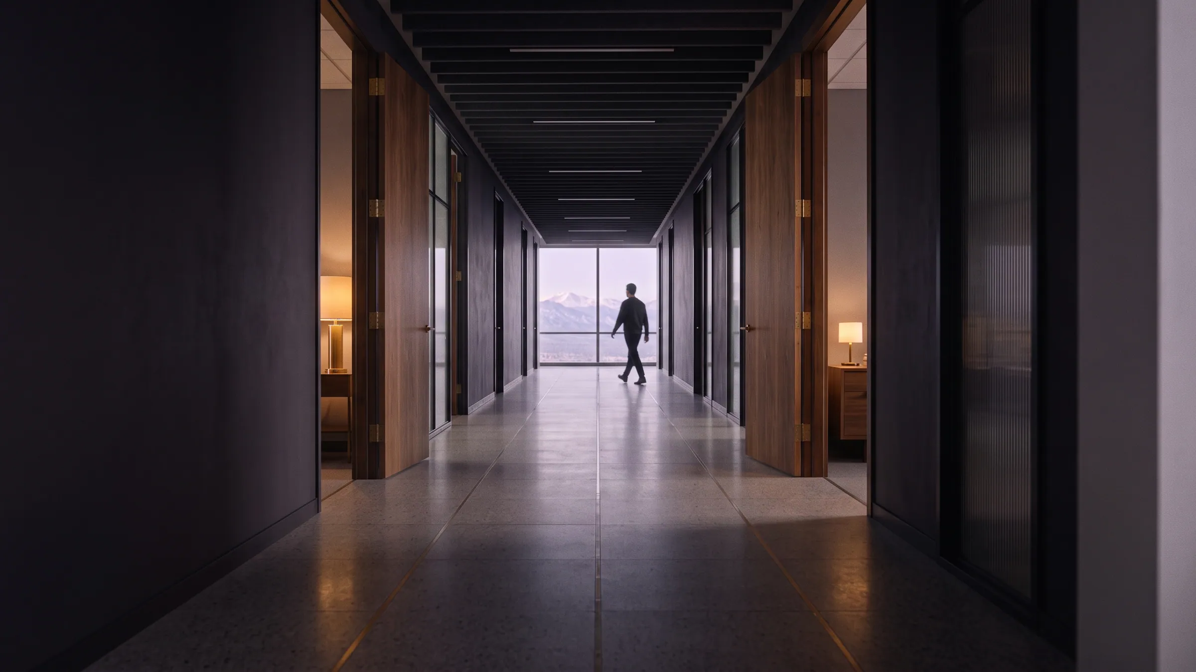 Office doors standing open along the corridor as someone walks toward the window.