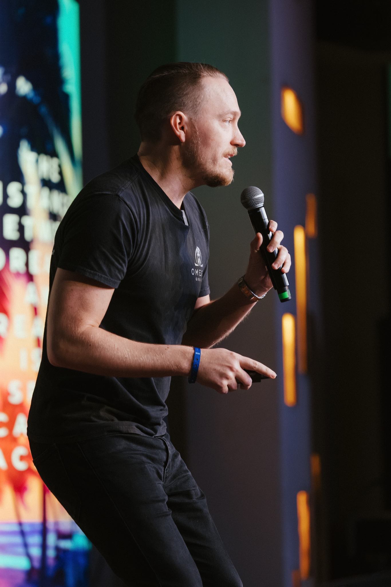 Jared Davis speaking on stage, microphone in hand